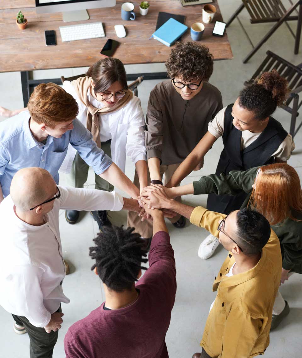 Group of young co-workers with hands together